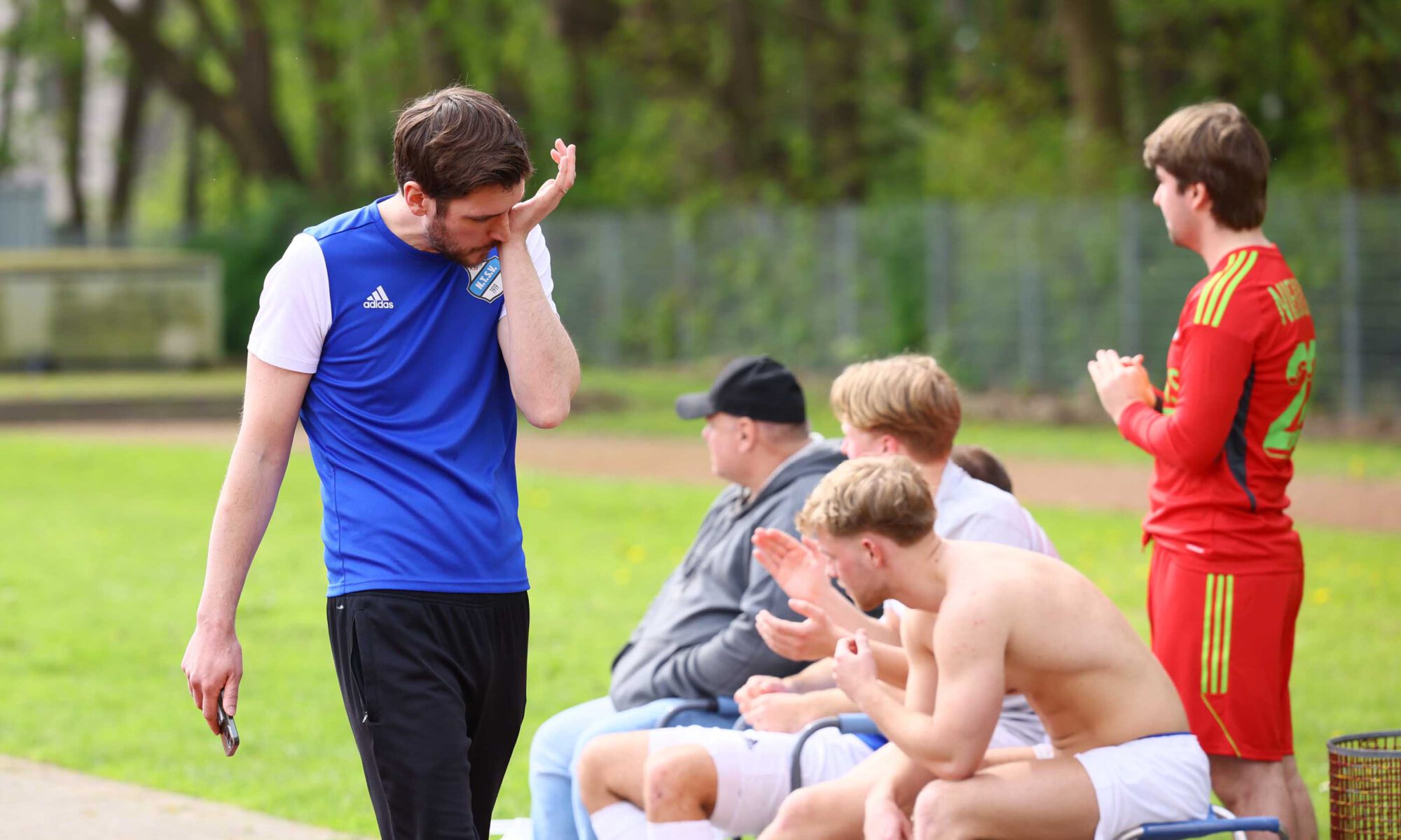 Jan-Hendrik Schmidt, Trainer der 3. Herren des Niendorfer TSV, wischt sich mit der Hand übers Gesicht an der Seitenlinie.